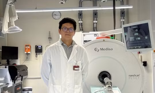 NCS Võ Hồng Phúc bên hệ thống PET/CT tiền lâm sàng dùng trong nghiên cứu tại Đức. Ảnh: NVCC.