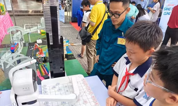 Hai bạn trẻ thích thú thi đấu cờ tướng với robot máy tính - Ảnh: ĐỨC THIỆN.