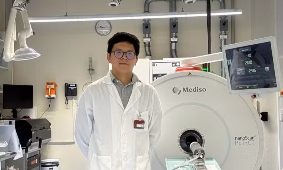 NCS Võ Hồng Phúc bên hệ thống PET/CT tiền lâm sàng dùng trong nghiên cứu tại Đức. Ảnh: NVCC.